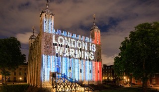 The Tower of London, illuminated in the climate stripes graphic with the message 'London is warming'
