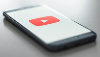Phone on a surface showing video player logo on the screen