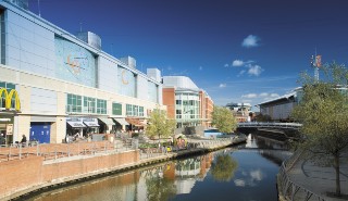 A picture of a canal running past shops and restaurants in Reading town centre