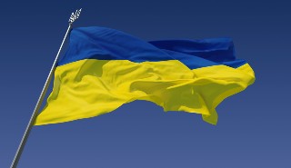 Flag of Ukraine flying in the breeze against a blue sky