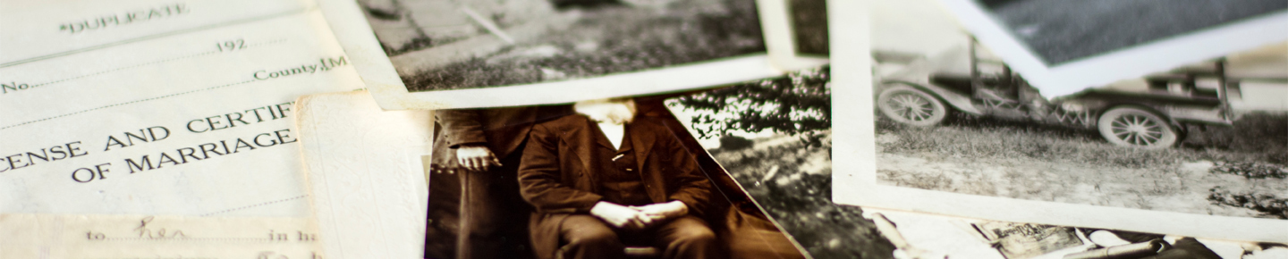 A pile of old documents, including an marriage certificate, a sepia photo of a man sitting, and black and white photos of old cars.