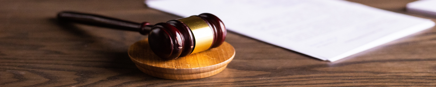 A gavel, a tool used in law, lying on a table.