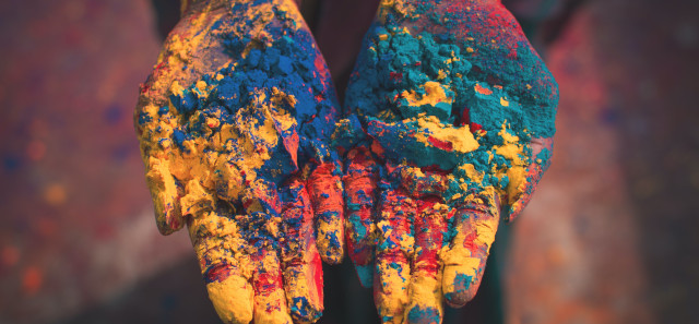 Someone holds out their hand covered in coloured dust in celebration of holi. 
