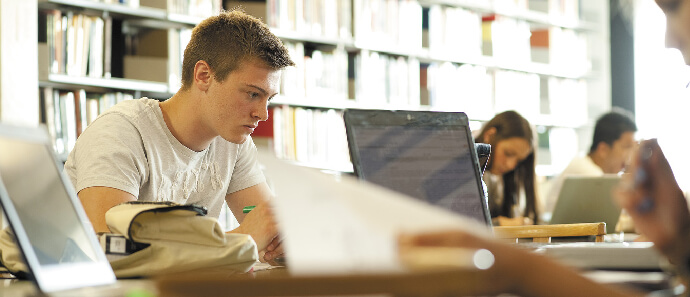 Students studying with laptops in the library.