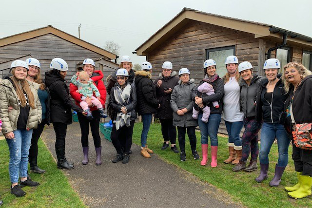 A group of women gathered for a group shot outside a building