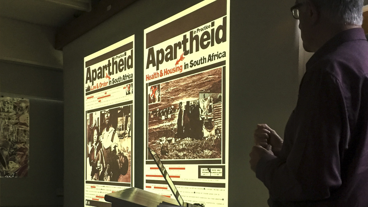 Lecturer presenting slide showing design related to Apartheid 