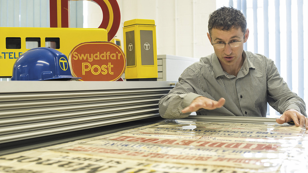 Lecturer looking at large poster in Department's archive